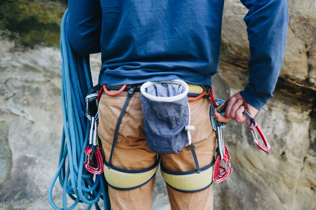 climber-geared-up-with-rope-harness-quickdraws-and-chalk-bag