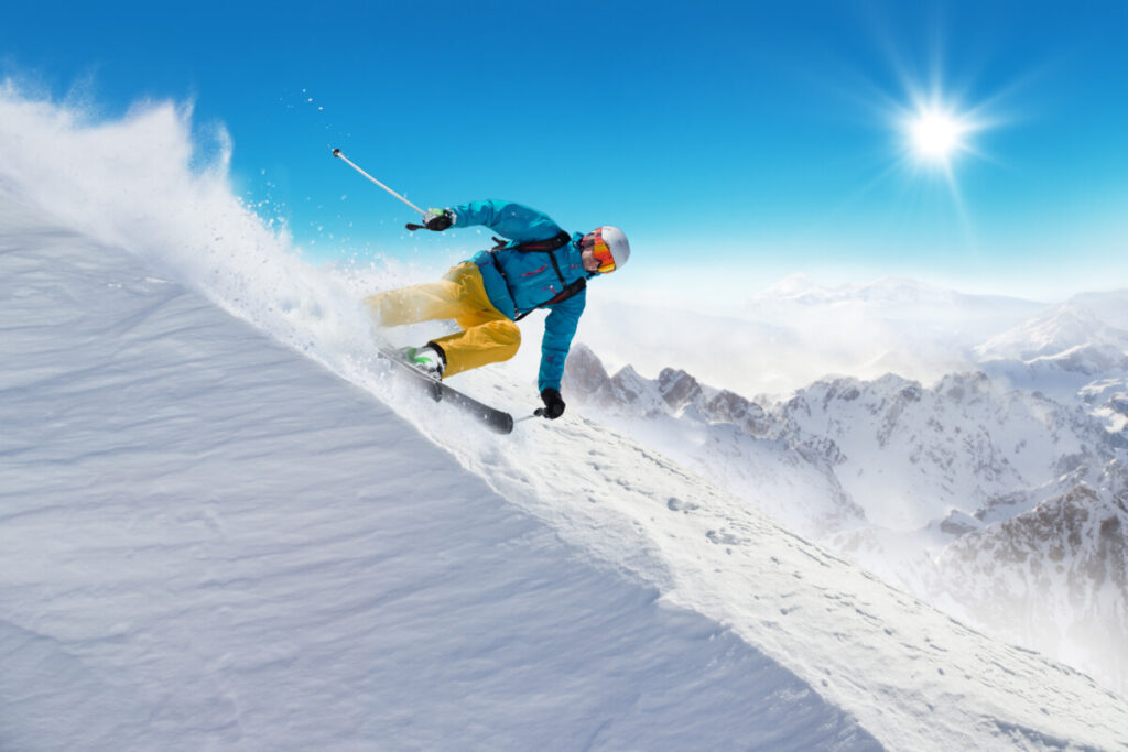backcountry-skier-shredding-ridgline-with-mountain-peaks-in-background